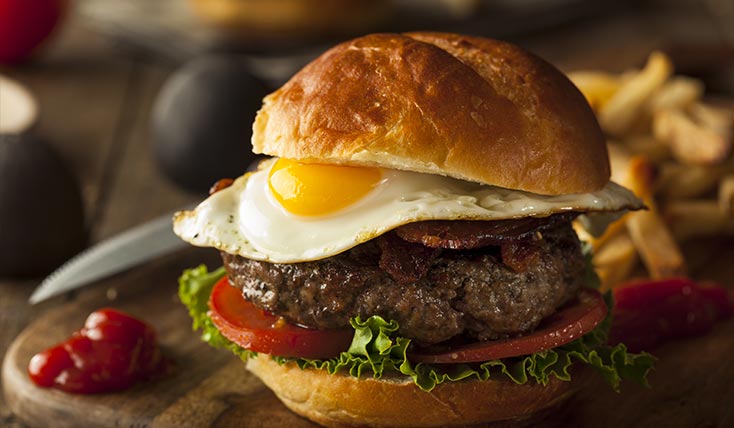 A hamburger with an egg on top of it.